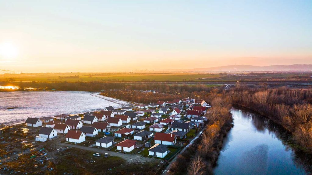 Fotografia rodinných domov a rieky pri západe slnka